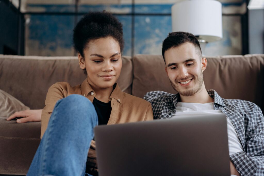 Couple talking to a therapist online via their laptop.